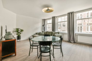 Mutfağın yakınındaki açık oturma odasındaki şöminenin yanındaki zarif avizenin altında yumuşak yastıklı büyük bir kanepe.