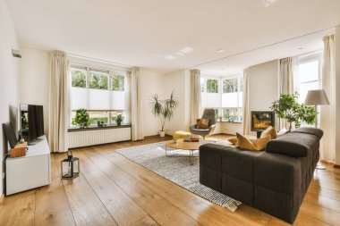 Günümüz minimalist tasarımı. Hafif stüdyo dairesinin ahşap masası ve oturma odası ile beyaz duvarları ve parke zemini arasında yemek masası ve sandalyeleri var.