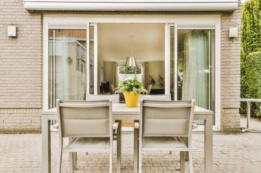 Oturma alanı ve ahşap çitlerin yanındaki küçük bahçesi olan düzgün asfaltlı bir avlu.