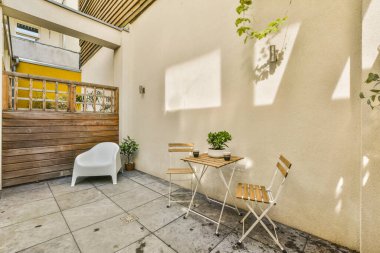 Neat powerful patio with sitting area and small garden near wooden fence