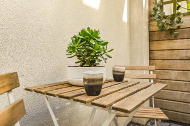 Neat powerful patio with sitting area and small garden near wooden fence