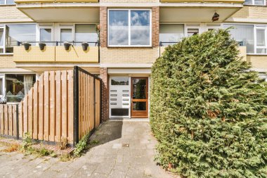 Ağaçlar ve fenerlerle dolu boş bir kaldırım sokağından tuğla evler manzarası