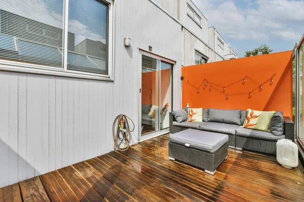 Neat paved patio with sitting area near wooden fence