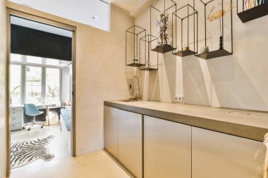 Minimalist tarzı beyaz mobilyalı, lavabolu ve sobalı bir ev mutfağı.