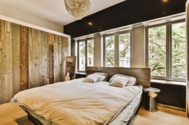 Yatak odasının iç tasarımı, yatak odası ve ahşap gardırop modern dairenin penceresinin kenarına yerleştirilmiş.