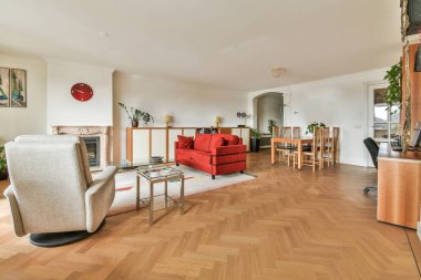 Şık bir oturma odası, rahat bir kanepe ve modern bir dairede masanın etrafına yerleştirilmiş yastıklı koltuklar.