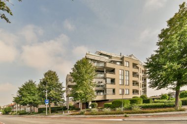 Arabaları, ağaçları ve fenerleri olan boş bir kaldırımdan panorama manzaralı evler.