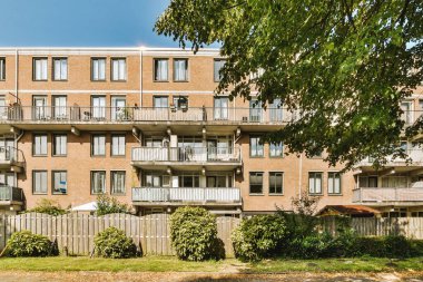 Ağaçlar ve fenerlerle dolu boş bir kaldırım sokağından tuğla evler manzarası