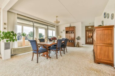 Lüks bir ev tasarımı. Yanan şömineli rahat bir oturma odası. Gün ışığında rahat bir kanepe ve halı.