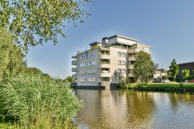Arabaları, ağaçları ve fenerleri olan boş bir kaldırımdan panorama manzaralı evler.