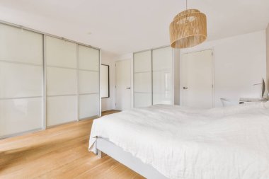 Yatak odasının iç tasarımı, yatak odası ve ahşap gardırop modern dairenin penceresinin kenarına yerleştirilmiş.