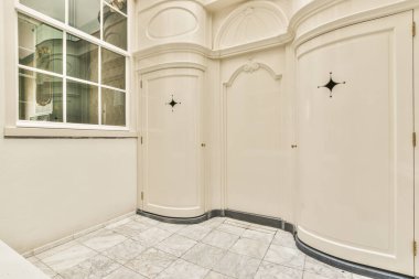 Beyaz duvarlı geniş koridorlu çağdaş dairenin iç mimarisi