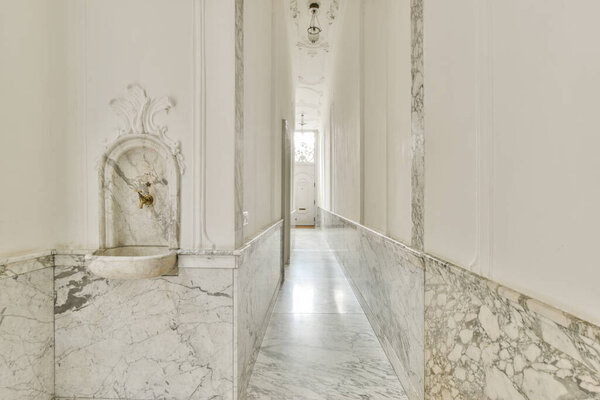 Light narrow hallway with door in white walls