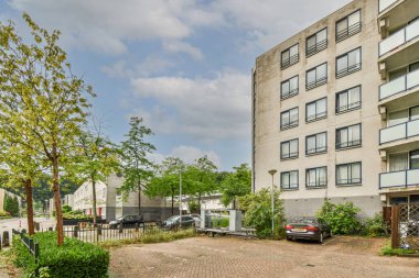 Arabaları, ağaçları ve fenerleri olan boş bir kaldırımdan panorama manzaralı evler.