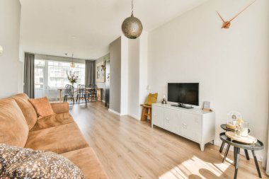 Masanın etrafına, modern dairede şık oturma odasının yemek alanında dekorasyonlar yerleştirilmiş kanepe ve koltuklar.