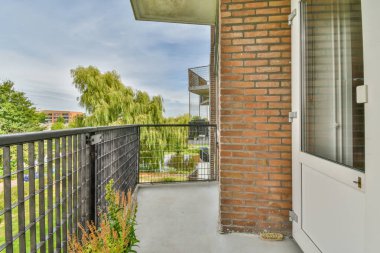 Küçük balkondan park edilmiş binaların ve ağaçların panoramik görüntüsü