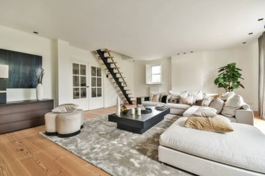 Yastıkları olan rahat bir kanepe. Duvara yaslanmış TV ve dekorasyonlar modern sevgi odasında.