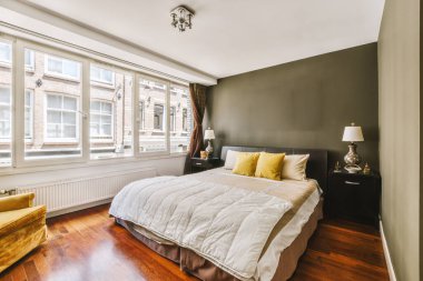 Yatak odasının iç tasarımı, yatak odası ve ahşap gardırop modern dairenin penceresinin kenarına yerleştirilmiş.