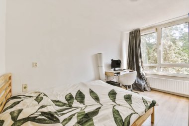 Yatak odasının iç tasarımı, yatak odası ve ahşap gardırop modern dairenin penceresinin kenarına yerleştirilmiş.