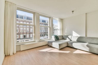 Çağdaş dairenin penceresinin yanındaki rahat kanepe