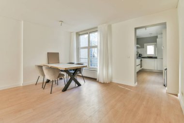 Modern mobilyalar ve aletlerle mutfağın yakınındaki ferah hafif yemek odasının içinde.