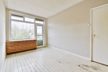 Evdeki boş ışık odasında, beyaz duvardaki plastik pencere ve radyatör.