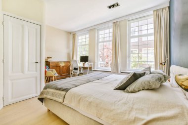 Yatak odasının iç tasarımı, yatak odası ve ahşap gardırop modern dairenin penceresinin kenarına yerleştirilmiş.