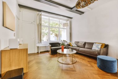 Günümüz minimalist tasarımı. Hafif stüdyo dairesinin ahşap masası ve oturma odası ile beyaz duvarları ve parke zemini arasında yemek masası ve sandalyeleri var.