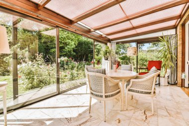 Neat paved patio with sitting area and small garden near wooden fence