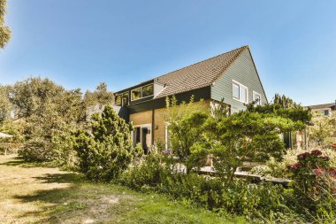 Oturma alanı ve ahşap çitlerin yanındaki küçük bahçesi olan düzgün asfaltlı bir avlu.