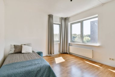 Yatak odasının iç tasarımı, yatak odası ve ahşap gardırop modern dairenin penceresinin kenarına yerleştirilmiş.