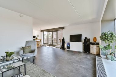 Yastıkları olan rahat bir kanepe. Duvara yaslanmış TV ve dekorasyonlar modern sevgi odasında.