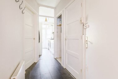 Işık dar koridor, beyaz duvarlarda birçok kapı ve kereste zemininde parlayan lamba