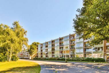 Ağaçlar ve fenerlerle dolu boş bir kaldırım sokağından tuğla evler manzarası