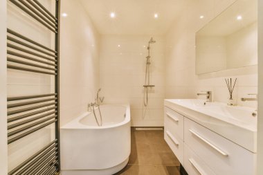 Aynalı lavabo ve temiz küvet modern banyoda cam kapılı ve beyaz fayanslı duvarları olan duş kutusunun yanında.