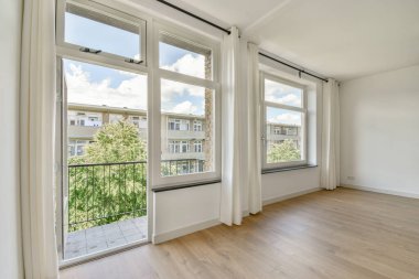 Evdeki boş ışık odasında, beyaz duvardaki plastik pencere ve radyatör.