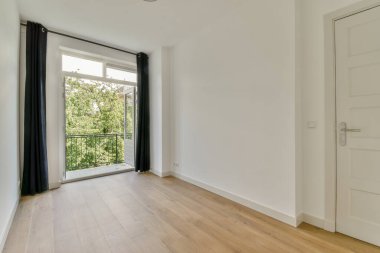 Evdeki boş ışık odasında, beyaz duvardaki plastik pencere ve radyatör.