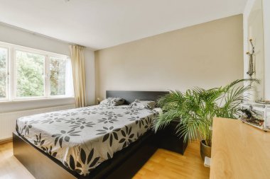 Yatak odasının iç tasarımı, yatak odası ve ahşap gardırop modern dairenin penceresinin kenarına yerleştirilmiş.