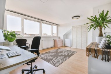 Boş tahtaya karşı bilgisayar monitörleri olan rahat sandalye ve çağdaş düz ev ofisinde ayna