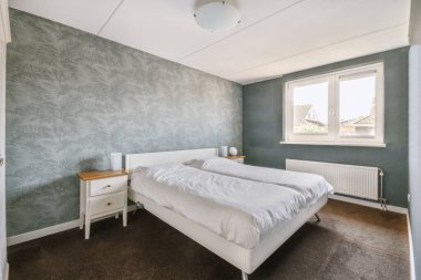 Yatak odasının iç tasarımı, yatak odası ve ahşap gardırop modern dairenin penceresinin kenarına yerleştirilmiş.