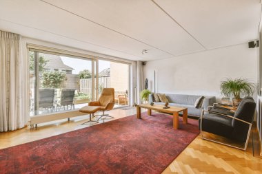 Günümüz minimalist tasarımı. Hafif stüdyo dairesinin ahşap masası ve oturma odası ile beyaz duvarları ve parke zemini arasında yemek masası ve sandalyeleri var.