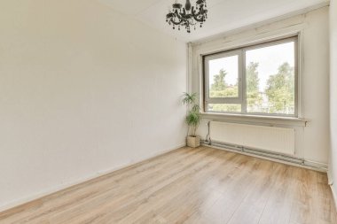 Evdeki boş ışık odasında, beyaz duvardaki plastik pencere ve radyatör.