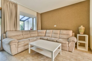 TV 'nin yanındaki koltuklar ve masa, çağdaş apartmandaki geniş odalı yemek alanına karşıdır.