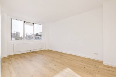 Evdeki boş ışık odasında, beyaz duvardaki plastik pencere ve radyatör.