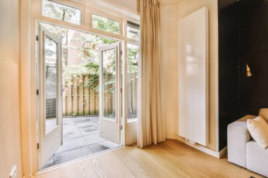 Çağdaş dairenin pencerelerine karşı rahat kanepesi ve televizyonu olan oturma odası.