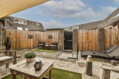 Ahşap çitlerin yanında basit, boş bir avlu.