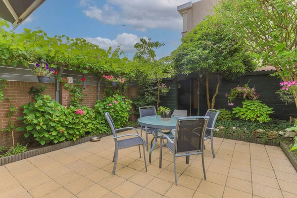 Neat powerful patio with sitting area and small garden near wooden fence