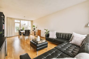 TV 'nin yanındaki koltuklar ve masa, çağdaş apartmandaki geniş odalı yemek alanına karşıdır.