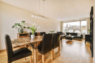 TV 'nin yanındaki koltuklar ve masa, çağdaş apartmandaki geniş odalı yemek alanına karşıdır.