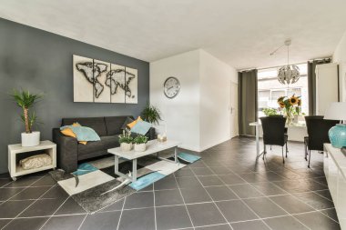 Çağdaş açık mutfak, yemek masası seti ve ferah odada gri kanepe.